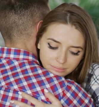 A young couple embracing indoors, expressing comfort and emotional support