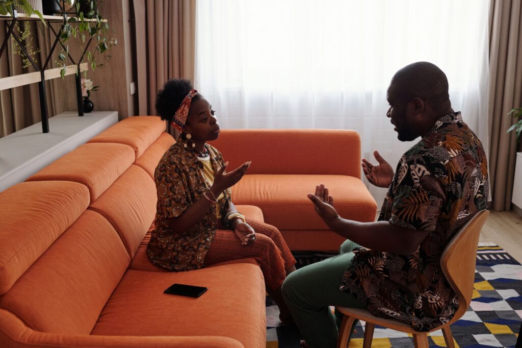 A couple having an emotional discussion on a sofa, working through distance