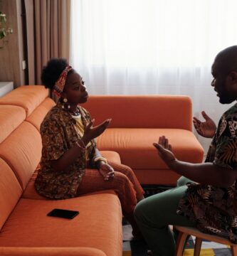 A couple having an emotional discussion on a sofa, working through distance