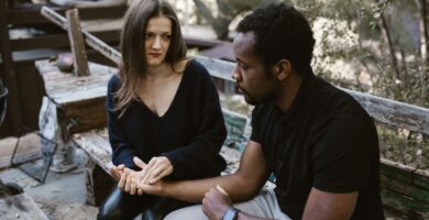 Couple having a serious conversation at home, one partner looking away defensively