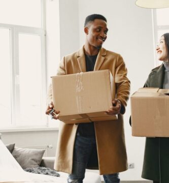 A couple happily unpacking boxes together in their new home, sharing a warm moment while moving in