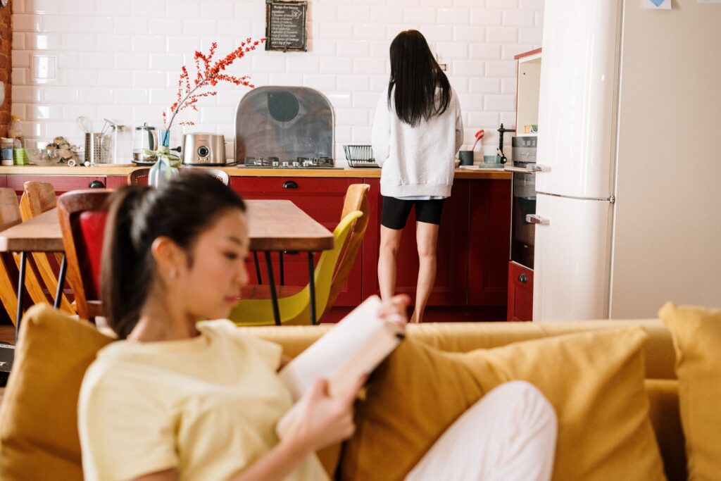 Couple sitting apart on a couch, feeling emotionally distant, representing the roommate phase in relationships