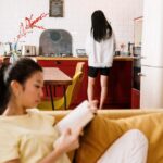 Couple sitting apart on a couch, feeling emotionally distant, representing the roommate phase in relationships