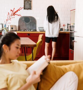 Couple sitting apart on a couch, feeling emotionally distant, representing the roommate phase in relationships